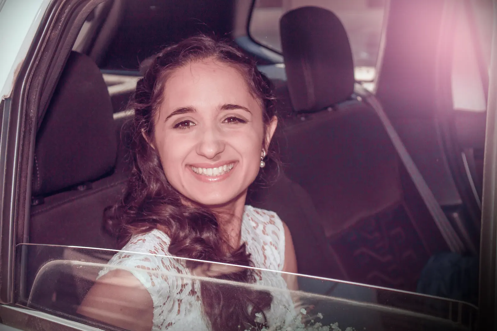 novia con vestido sonriendo desde automóvil