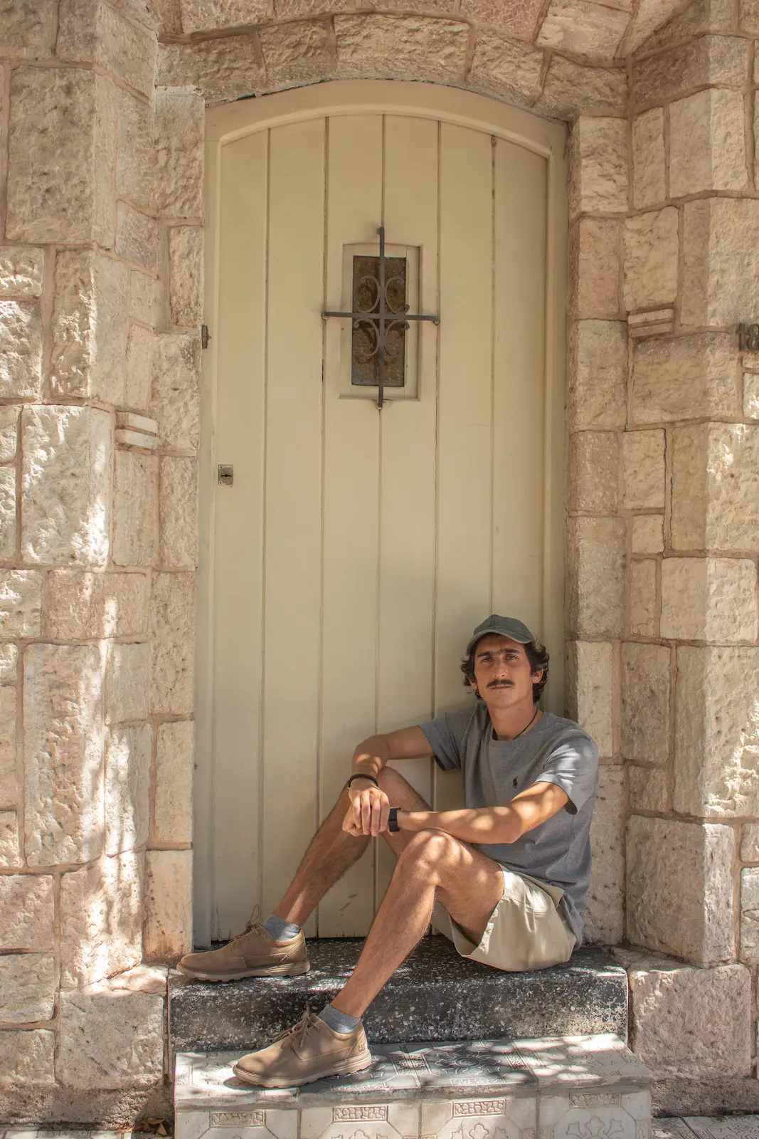 joven sentado en la puerta de una casa