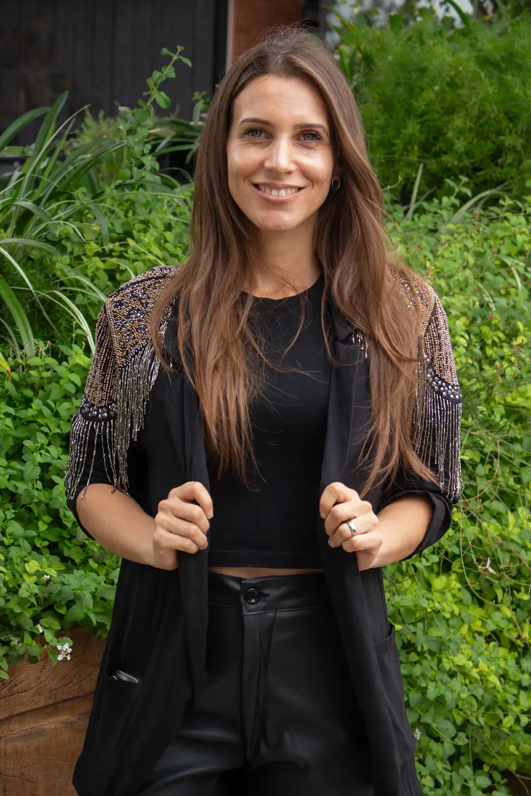 mujer sonriendo sobre fondo natural de plantas