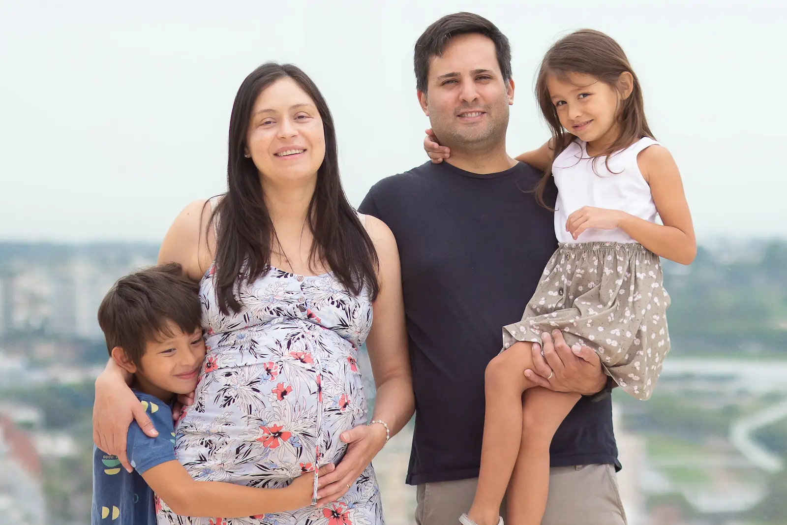 foto familiar, con mama embarazada y dos niños sonriendo
