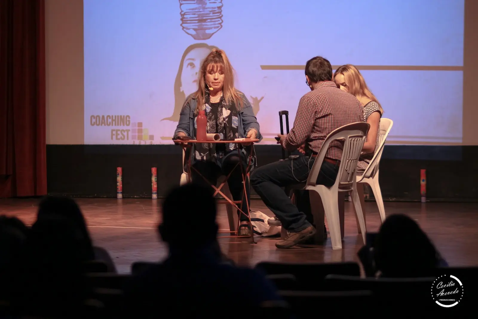 personas conversando sobre una mesa en un escenario